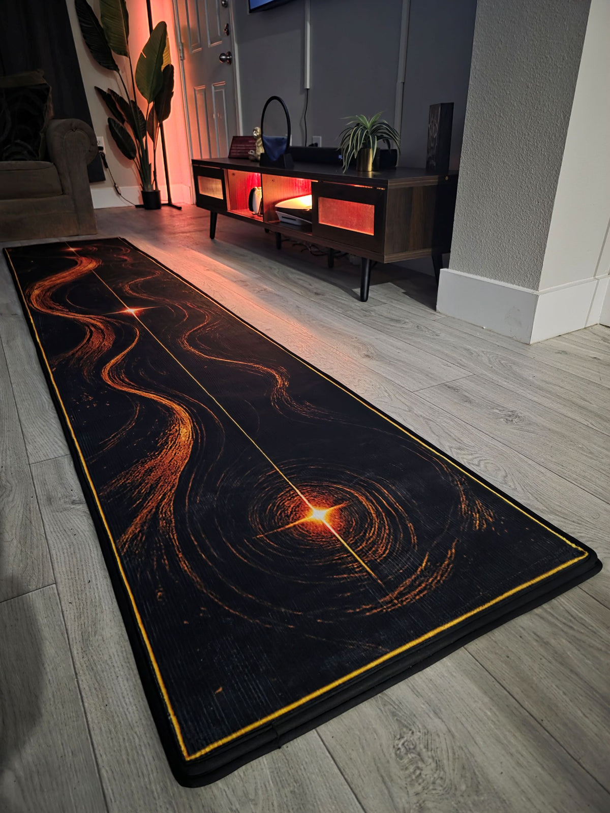 Oryan's Belt designer putting rug with black and copper celestial artwork in a contemporary room